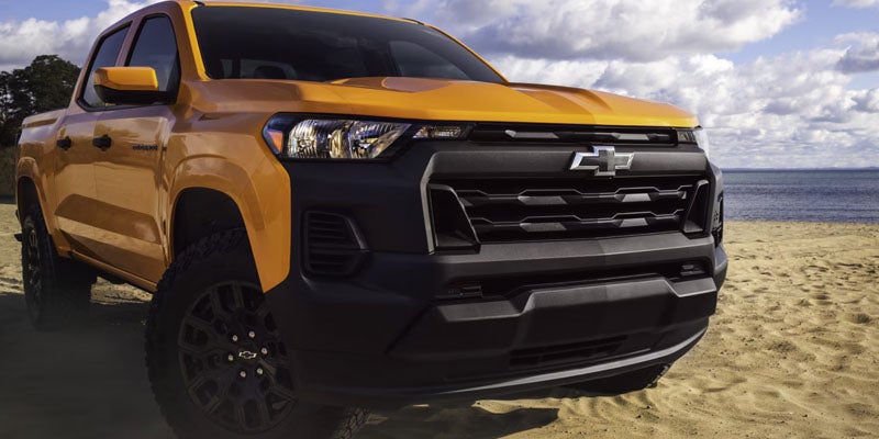 A Chevy Colorado displayed in a vibrant orange color, showcasing its bold design and rugged features.